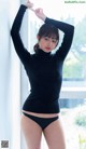 A woman in a black turtle neck sweater and black panties.