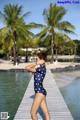 A woman in a polka dot swimsuit standing on a dock.