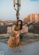 A woman standing on top of a building next to a street light.