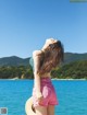 A woman standing on the edge of a body of water.